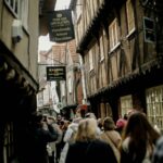 a group of people walking down a street next to tall buildings
